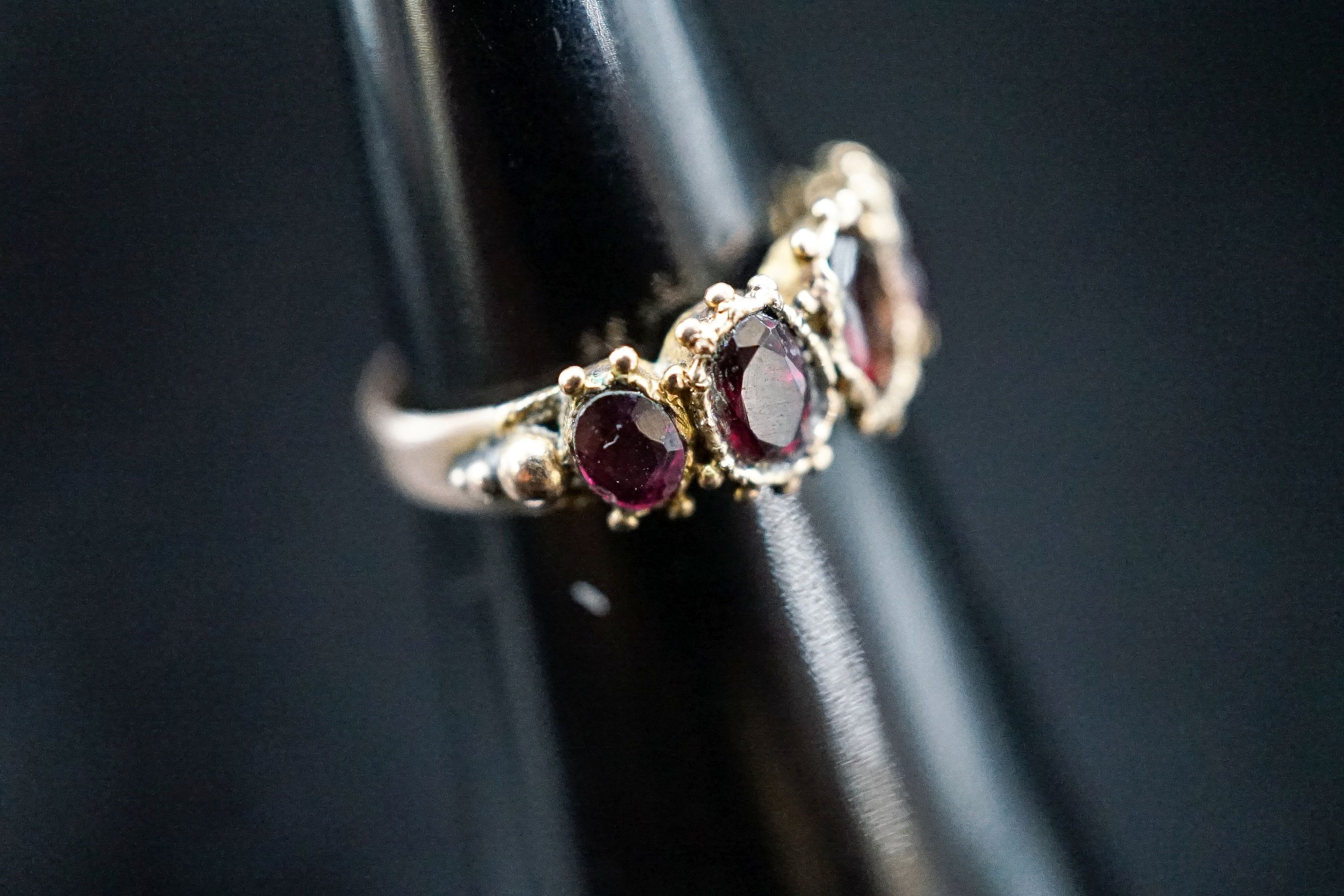 A 19th century yellow metal and graduated five stone garnet half hoop ring, size K, gross 2,.1 grams.